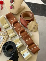 Cinturón marrón con textura símil piel de cocodrilo, argollas plateadas y remaches.