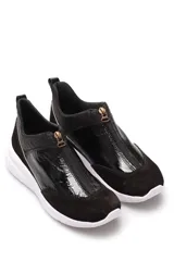 Zapatillas deportivas negras de cuero con cierre dorado en el empeine y suela blanca.
