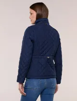 Campera capitoneada negra con costuras multidireccionales, cuello alto, cierre frontal y bolsillos laterales con cierre.