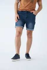 Bermuda de jean azul con lavado clásico, diseño de cinco bolsillos, cierre de cremallera y botón, con detalle de botamanga doblada.