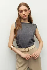 Top sin mangas color beige, de cuello redondo y corte ajustado. Presenta frunces en los laterales.