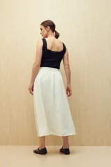 Falda midi color blanco con estampado de lunares negros.
