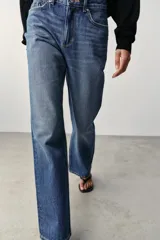 Jeans de tiro alto, pernera recta y larga, estilo clásico con cinco bolsillos, cierre frontal con cremallera y botón metálico.