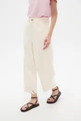 Pantalón jean slouchy de tiro alto, color natural, con detalle de bordadoado en el borde inferior.