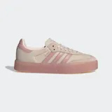 Championes Adidas Sambae, una versión actualizada del modelo Samba con una suela elevada y gruesa de color rosado translúcido. El exterior es de cuero nobuk color beige claro con las 3 rayas dentadas y refuerzo en la puntera en color rosado pálido.