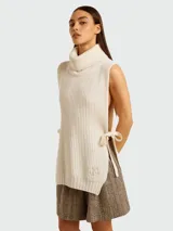 Chaleco de lana color crema con cuello alto y lazos laterales.