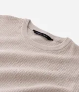 Suéter de punto con textura en zig zag, cuello redondo y manga larga con puños ajustados. Confeccionado en una mezcla de algodón y poliamida.