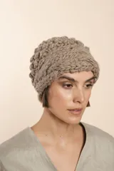 Gorro tejido a mano con hilado rueca, color beige. Presenta variedad de texturas: punto garbanzo y guarda con diseño de trenzas.