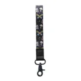 Llavero de muñeca con correa de poliéster negra y estampado de hongos, polillas y estrellas. Cuenta con una presilla de cuero sintético y gancho metálico oscuro.