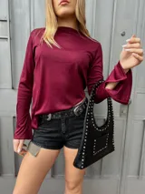 Remera bordó de manga larga con corte en la bocamanga y terminación en pico.