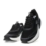 Championes Umbro Vex de hombre, color negro con detalles en blanco y gris. Presentan una capellada de malla transpirable, cordones negros, logo de Umbro en el lateral y una suela gruesa con amortiguación.