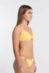 Bombacha de bikini colaless de textura gofrada en color amarillo, con tiras laterales finas y argollas carey decorativas en las caderas.