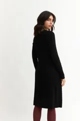 Vestido tejido azul marino de corte a la rodilla, con cuello redondo y mangas largas.