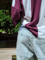 Pantalón de jean celeste lavado, de corte ancho y tiro alto con cordón ajustable en la cintura. Presenta detalles deshilachados en los bajos.