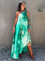 Vestido largo verde con diseño estampado tipo tie-dye y detalles dorados, de corte fluido, un solo hombro y diseño amplio.