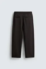 Pantalón regular fit color marrón oscuro, confeccionado en tejido con viscosa. Cuenta con cintura elástica, bolsillos delanteros y detalle de bolsillos traseros de vivo. El cierre frontal es con cremallera y botón.