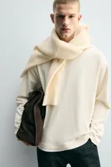 Camiseta de manga larga con corte relajado y cuello redondo. Presenta un diseño de doble capa con acabados en rib a contraste en el cuello y el ruedo.