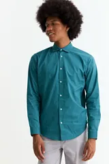 Camisa de manga larga color verde azulado (teal) con cuello clásico y botones frontales blancos.