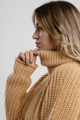 Sweater negro de tejido de punto grueso, con cuello alto y mangas largas.