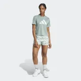 Remera deportiva Adidas Run It Bl, color verde salvia, de manga corta y cuello redondo. Presenta el logo de las tres barras en el frente con un diseño estampado en blanco.