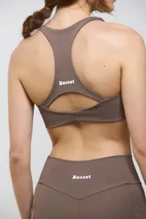 Top deportivo de compresión media con escote redondo, diseño al cuerpo y espalda abierta. Cuenta con elástico interno en la cintura para mayor sujeción.