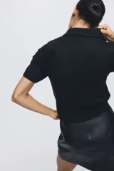 Saco de punto de manga corta con cuello camisero, cierre frontal con botones decorados con strass y terminaciones acanaladas en mangas y ruedo.