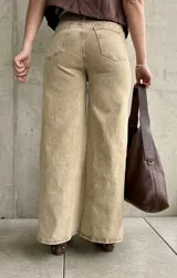 Pantalón de jean color beige con efecto óxido, de tiro alto y corte ancho en las piernas.