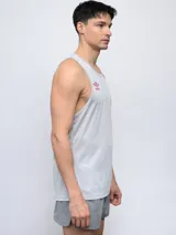 Musculosa deportiva Umbro color gris claro, con cuello redondo y logo Umbro en color rojo en el pecho. Presenta tejido de malla en la espalda para mayor ventilación.