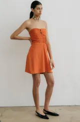 Vestido corto strapless color naranja, con frunce en el frente y falda semi acampanada.