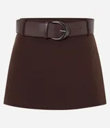 Short pollera de sastrería color marrón, con caída estructurada, trabillas en la cintura e incluye un cinturón desmontable de cuerina con hebilla metálica.