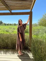 Vestido verde oliva de lino, corte suelto, con mangas abullonadas y volado en el ruedo.