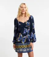 Vestido corto de viscosa y lino con estampado de mariposas, escote en pico y mangas largas abullonadas.