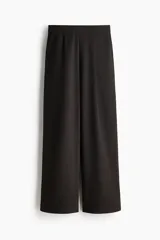 Pantalón de punto de corte holgado y tiro alto con elástico oculto en la cintura, piernas amplias con pinzas y bolsillos al bies.