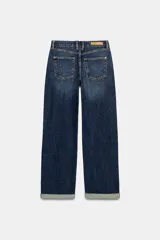 Jeans de tiro medio y corte relaxed fit, color azul con efecto deslavado, diseño de cinco bolsillos y bajo vuelto. Cuenta con cierre frontal de cremallera y botón metálico.