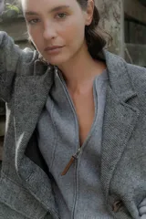 Tapado de corte recto y largo midi, confeccionado en tejido con textura de espiga en tonos grises. Presenta solapas clásicas, cierre frontal con botones y bolsillos laterales amplios con solapa.