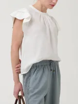Blusa de algodón orgánico y ramie, color blanco, con cuello redondo y mangas cortas adornadas con detalles de crochet.