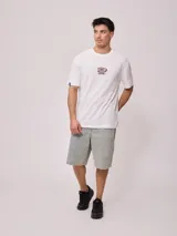 Remera blanca de algodón con estampa en la espalda con el logo de Rusty y la leyenda 'Since chasing surf records 1985'.