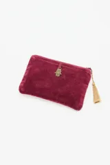 Billetera tipo sobre de terciopelo color bordó con estrellas bordadas en hilo dorado. Cuenta con cierre superior y un tirador decorativo con borla de hilo dorado.