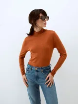 Sweater de punto color ladrillo, con cuello alto y mangas largas.