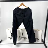 Pantalón cargo de nylon negro, corte holgado con bolsillos laterales con solapa y cintura elástica ajustable con cordón.