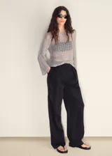 Jersey de punto calado color gris, con diseño de red transparente, cuello redondo y mangas largas acampanadas.
