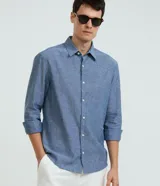 Camisa comfort de manga larga y cuello inglés, confeccionada en mezcla de lino y algodón. Presenta un diseño básico sin estampa con cierre frontal de botones.