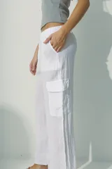 Pantalón de lino blanco, de corte recto y tiro alto, con bolsillos laterales y traseros.