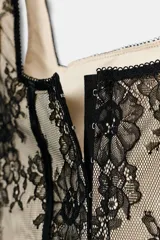 Corset confeccionado en poliamida con diseño de encaje floral y varillas estructuradas visibles. Presenta escote recto, tirantes anchos y forro interior en tono contrastante.
