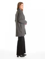 Cardigan largo de tejido de punto suave, color gris, con cuello con caída fluida, mangas largas con hombros caídos y bolsillos laterales discretos.