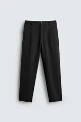 Pantalón de corte recto confeccionado en tejido elástico, con cintura elástica, pliegues frontales, bolsillos laterales y bolsillos traseros de vivo con botón.