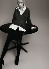Jersey de punto jaspeado en tonos grises y negros, con cuello en V profundo, mangas largas y diseño recto holgado.
