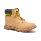 Botín unisex de cuero color miel, con cuello acolchado negro, cordones amarillos y suela marrón. Presenta el logo de Caterpillar en amarillo y negro en el lateral.