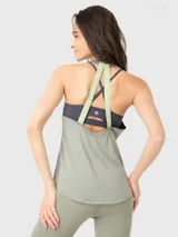 Musculosa deportiva de mujer, color verde, con cuello redondo y diseño sin mangas. Presenta un calce regular y tejido liviano y fresco, ideal para actividades físicas.