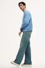 Buzo azul claro de tejido de mezcla de algodón, con interior cepillado suave, cuello redondo ribeteado, hombros caídos y remate acanalado ancho en puños y bajo. Corte holgado.